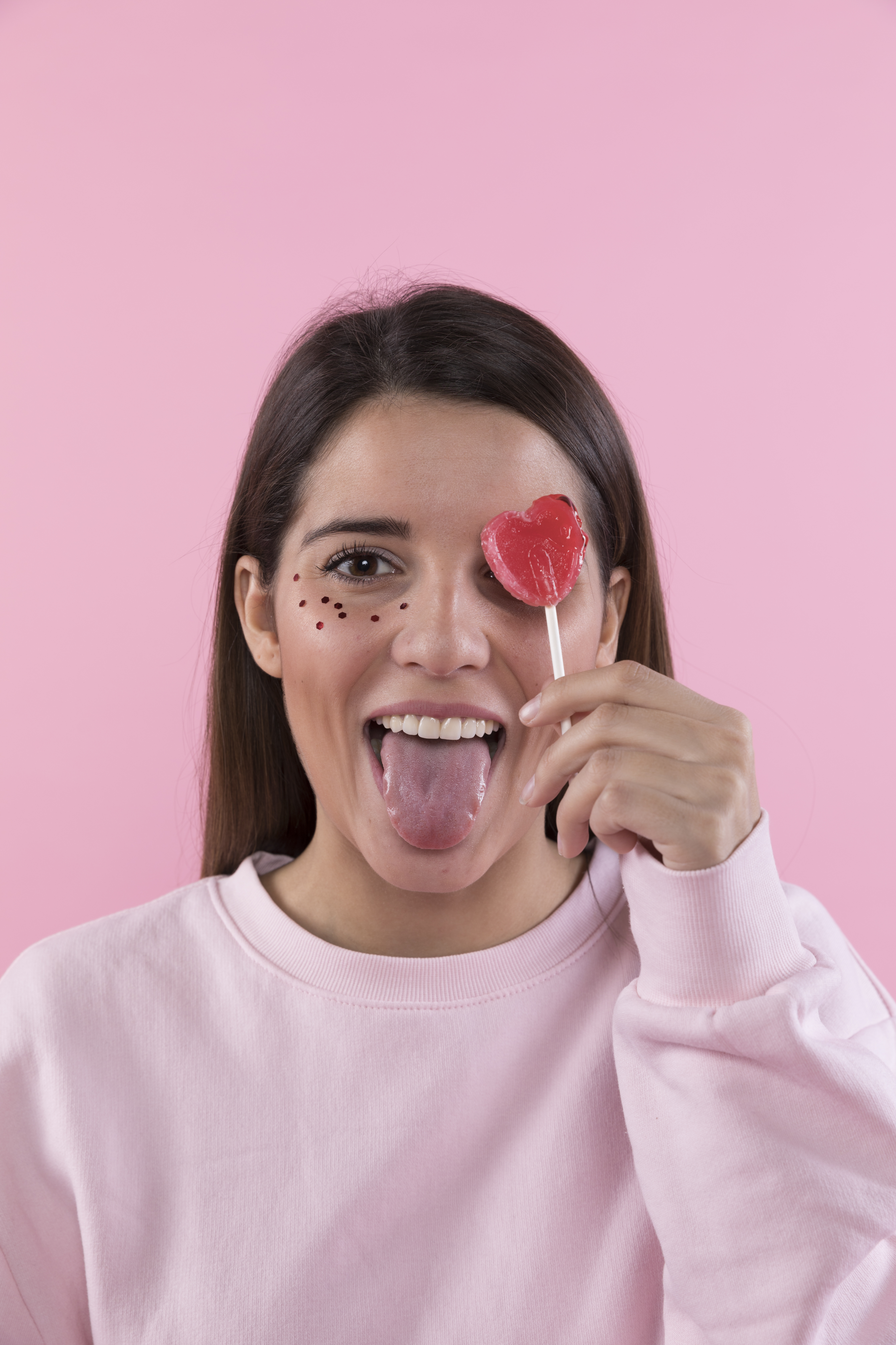 young-lady-having-fun-with-ornament-glitters-face-lollipop (1)